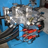 An integrated hydraulic circuit consisting of a manifold block, a Cetop 8 Safety Valve Assembly, large ball valves (fitted with safety limit switches), and cartridge flow control valves.